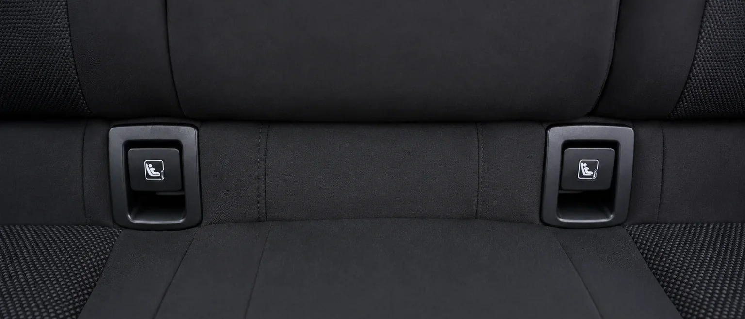 Anclajes Isofix visibles entre el respaldo y el asiento trasero de un coche