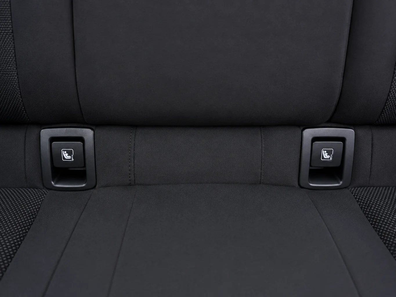 Los dos conectores Isofix visibles entre el respaldo y el asiento trasero de un coche