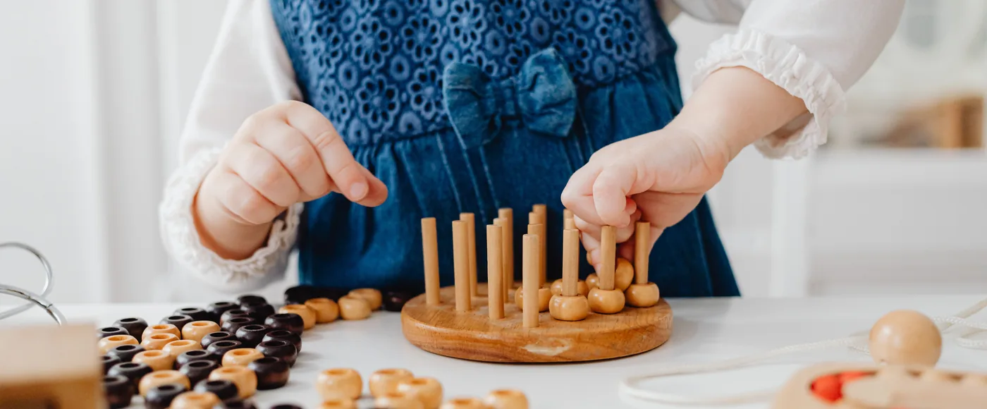 Niña jugando con un juguete de clasificación de madera