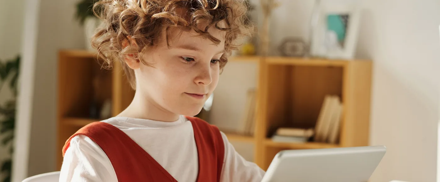 Niño mirando una tablet con luz natural